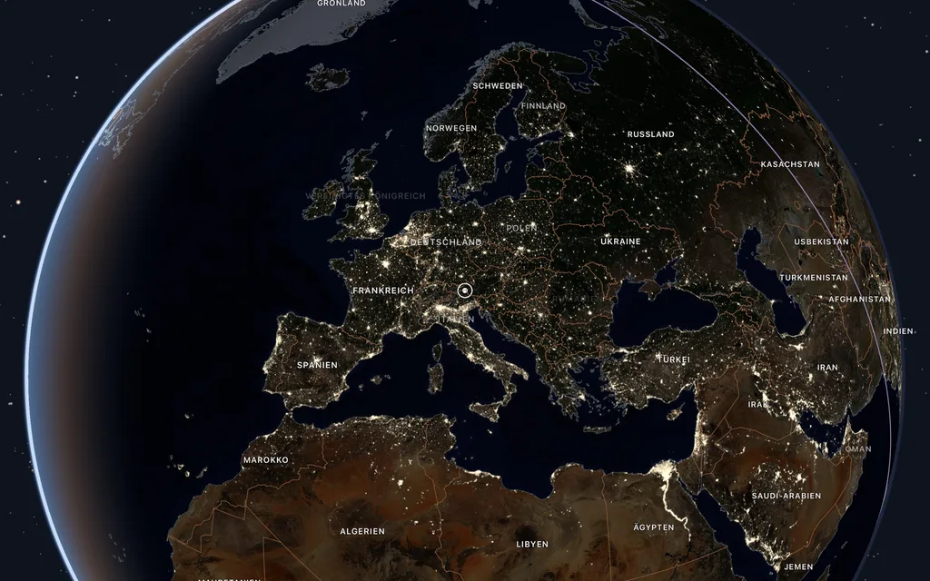Europa bei Nacht mit den Lichtern der Städte, am Rand des Globus noch Abendlicht